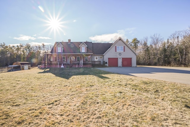 view of front of house with a front yard, covered porch, and a garage