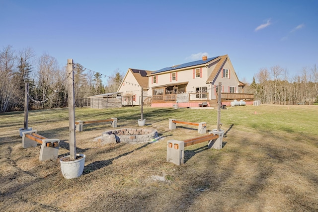 exterior space featuring solar panels, a lawn, and a wooden deck