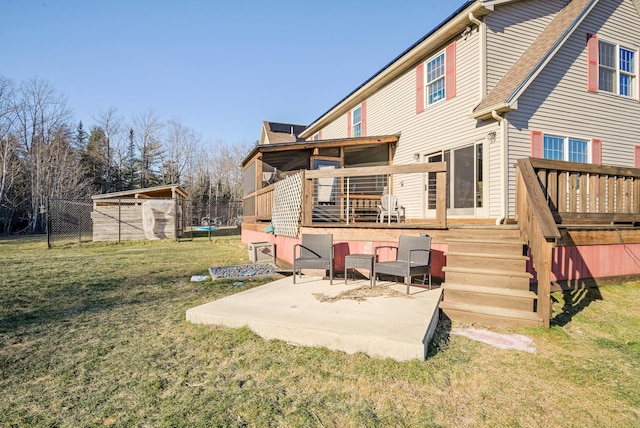 back of house featuring a deck, a patio area, and a yard