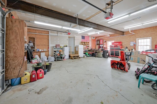 garage with a garage door opener and a workshop area