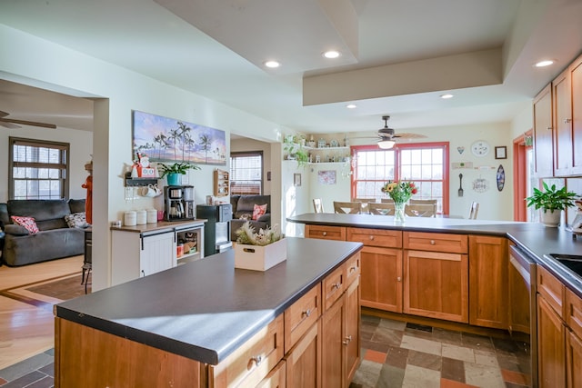 kitchen with stainless steel dishwasher, a center island, ceiling fan, and kitchen peninsula