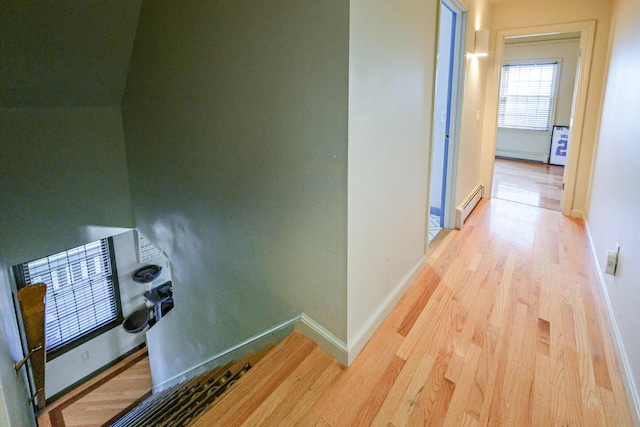 hall featuring baseboard heating and light hardwood / wood-style flooring