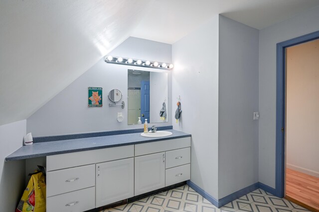 bathroom with lofted ceiling and vanity