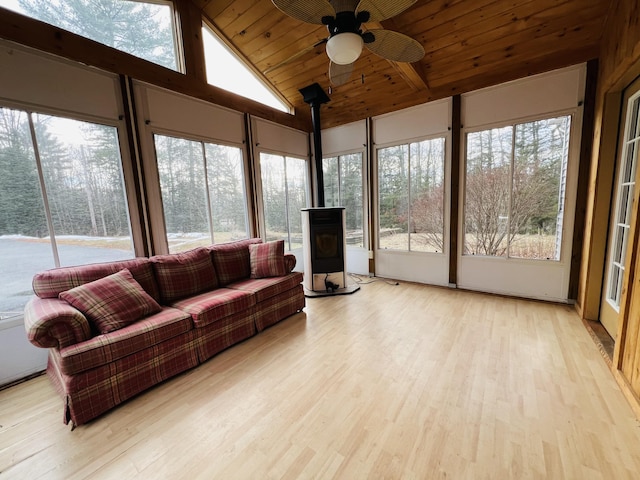 sunroom / solarium with wooden ceiling, a wealth of natural light, and a wood stove