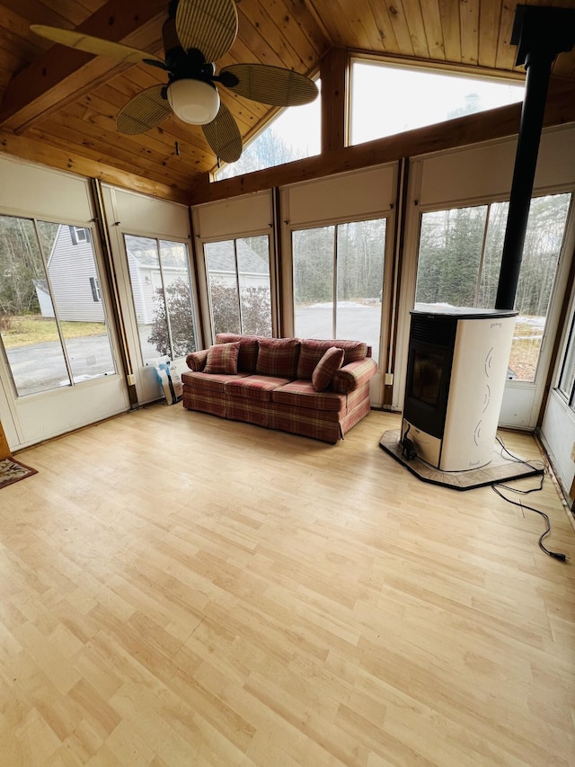 living room with wood ceiling, ceiling fan, a wood stove, light wood-type flooring, and vaulted ceiling