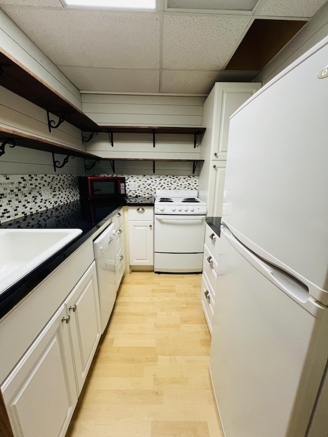 kitchen featuring white cabinetry, tasteful backsplash, white appliances, light wood-type flooring, and a drop ceiling