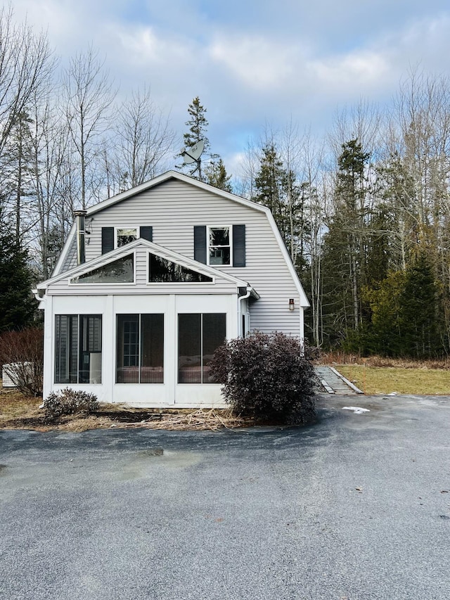 view of property exterior with a sunroom