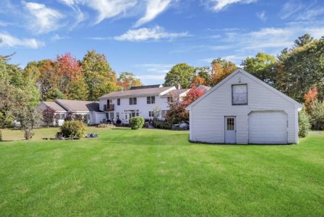 back of property featuring a yard, a garage, and an outdoor structure