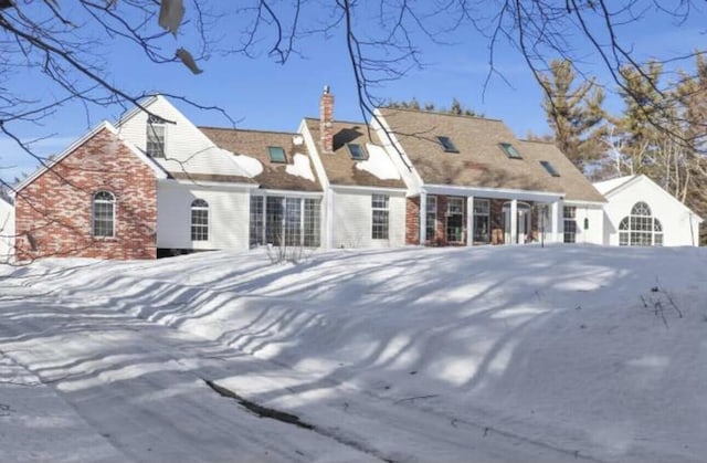 view of snow covered back of property