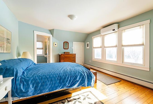 50 Peters Rd, Searsmont, ME 04973 - bedroom featuring a wall mounted AC, a baseboard heating unit, hardwood / wood-style flooring, and lofted ceiling