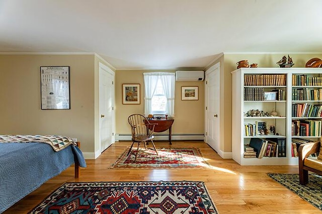 50 Peters Rd, Searsmont, ME 04973 - bedroom featuring ornamental molding, a wall mounted AC, wood finished floors, a baseboard radiator, and baseboards