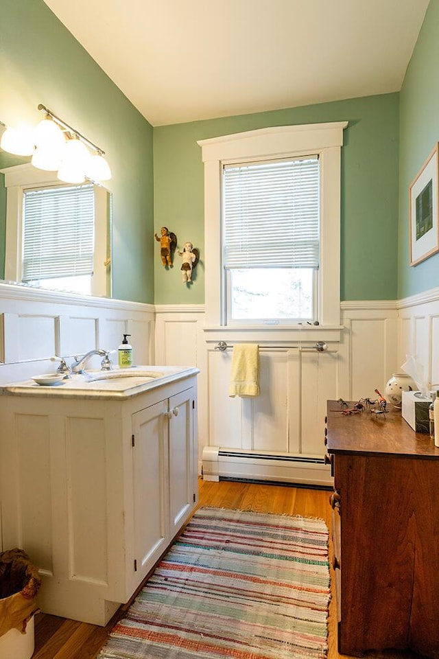 50 Peters Rd, Searsmont, ME 04973 - bathroom featuring vanity, wainscoting, wood finished floors, and baseboard heating