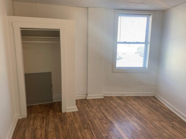 unfurnished bedroom with dark wood-type flooring and a closet