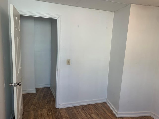 hallway with dark hardwood / wood-style flooring