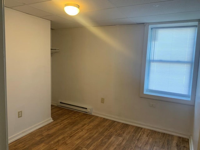 empty room featuring dark hardwood / wood-style flooring and a baseboard radiator