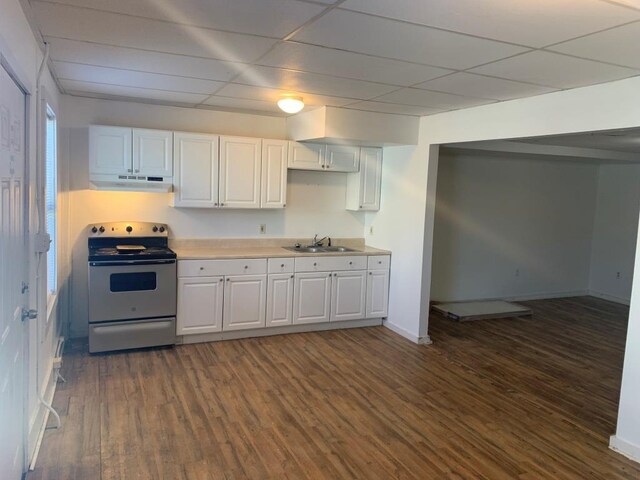 kitchen featuring stainless steel electric stove, a paneled ceiling, dark wood-type flooring, white cabinets, and sink