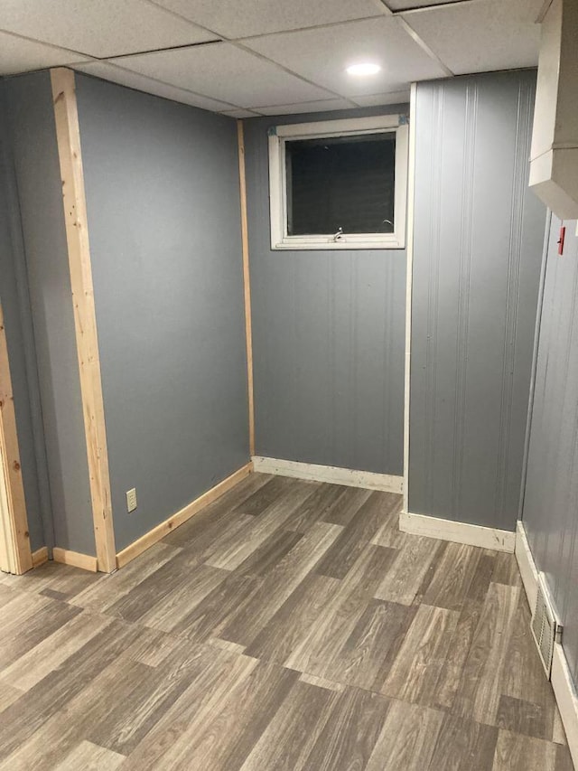 basement with wood-type flooring and a drop ceiling