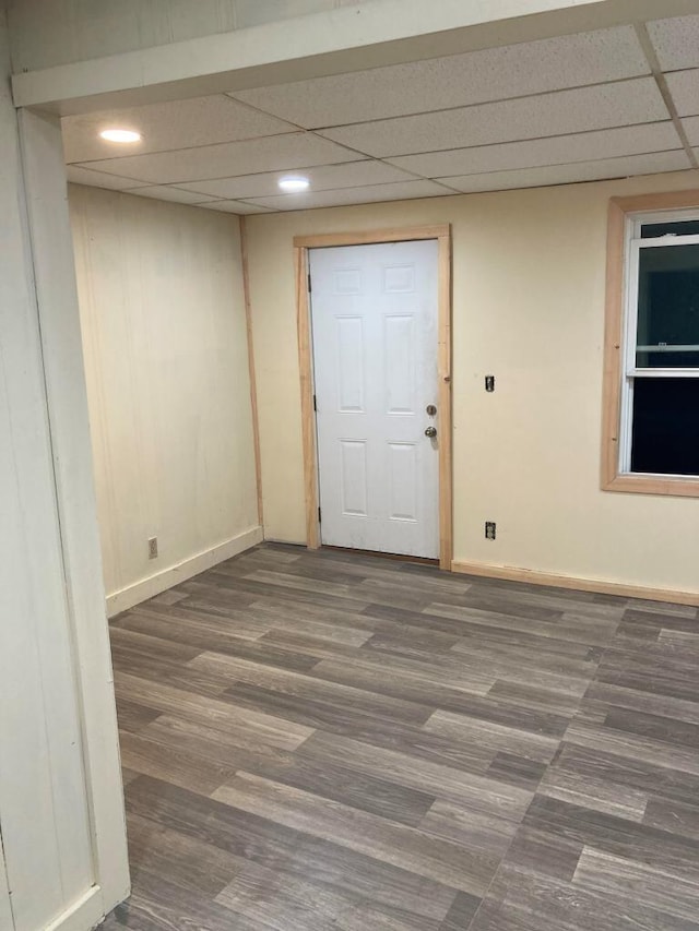 unfurnished room featuring a paneled ceiling and dark hardwood / wood-style flooring