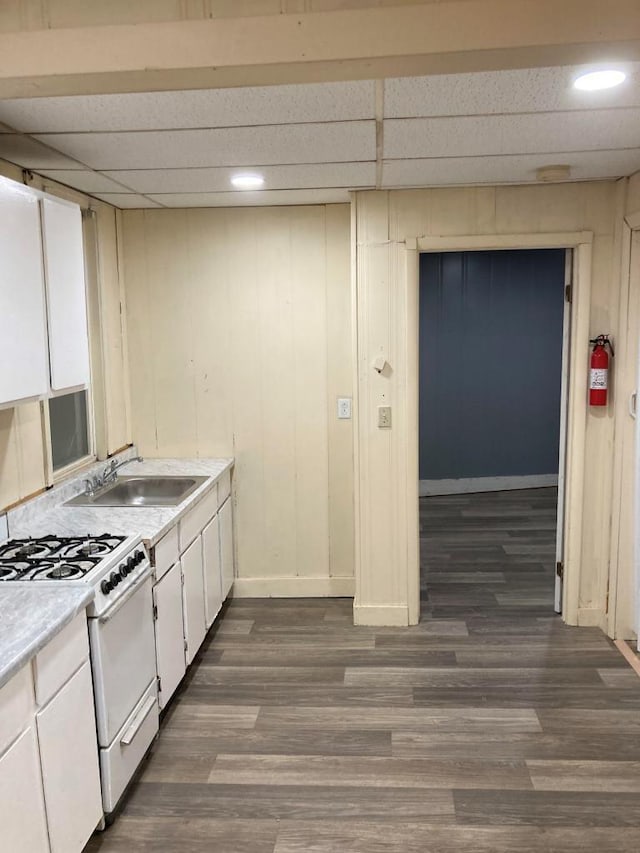 kitchen with sink, white gas range oven, a paneled ceiling, and white cabinetry