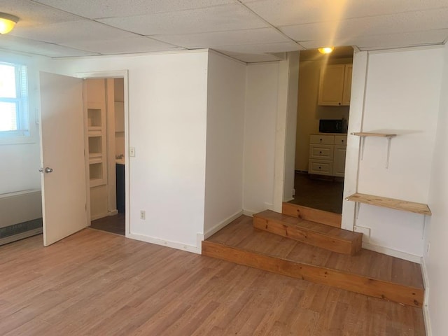 unfurnished room featuring light hardwood / wood-style flooring and a drop ceiling