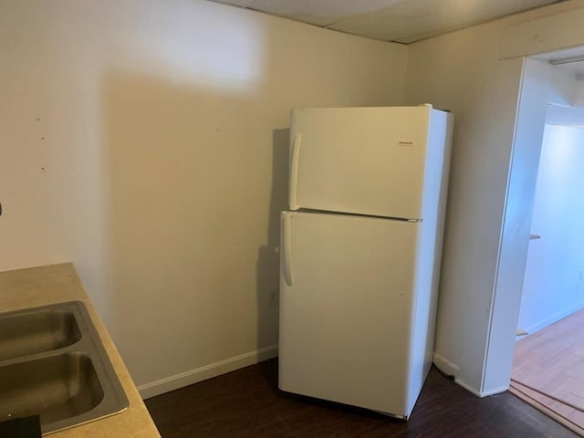 kitchen with white fridge and dark wood-type flooring