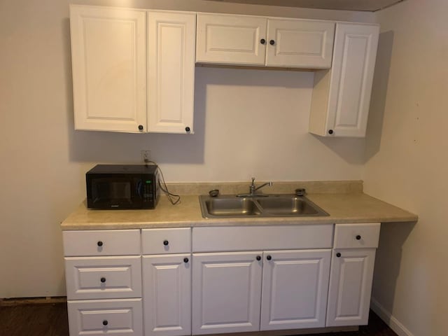 kitchen featuring white cabinetry and sink