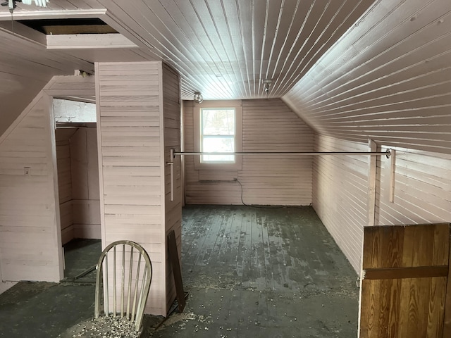 additional living space featuring lofted ceiling and wood walls