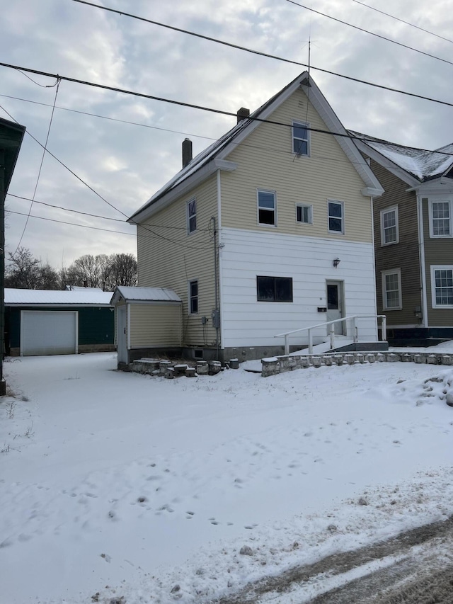 view of front facade with a garage and a storage shed