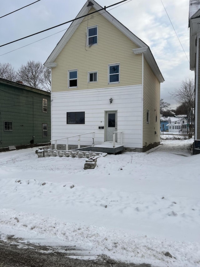 view of snow covered rear of property