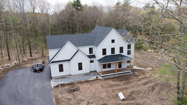 5 Red Oak Dr, Falmouth, ME 04105 - view of front facade featuring a standing seam roof, a view of trees, metal roof, and roof with shingles
