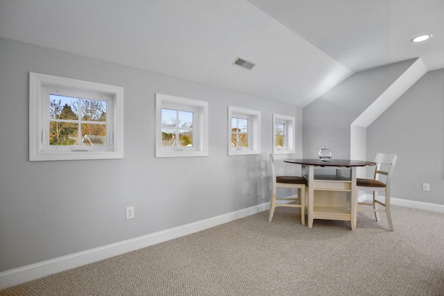 carpeted dining room with a healthy amount of sunlight and lofted ceiling