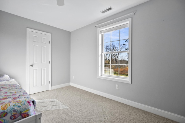 unfurnished bedroom featuring multiple windows, carpet floors, and ceiling fan