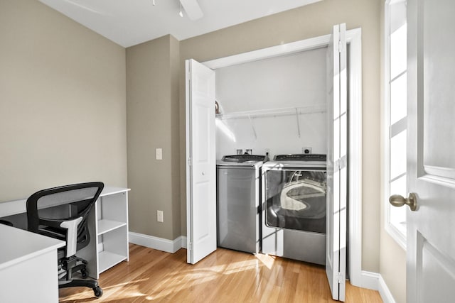 laundry room featuring ceiling fan, washing machine and clothes dryer, and light hardwood / wood-style flooring