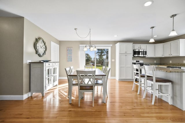 dining room with an inviting chandelier and light hardwood / wood-style floors