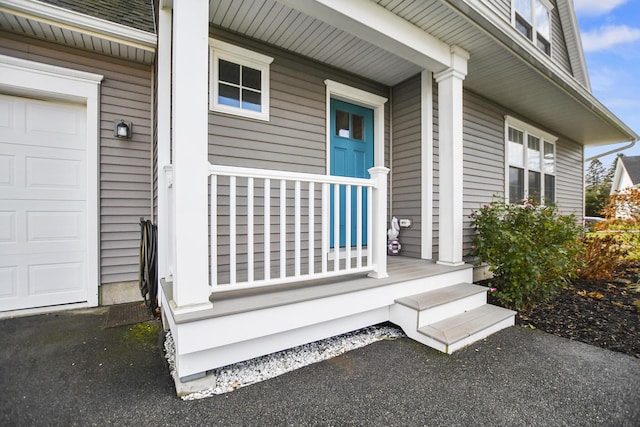 doorway to property featuring a garage and a porch