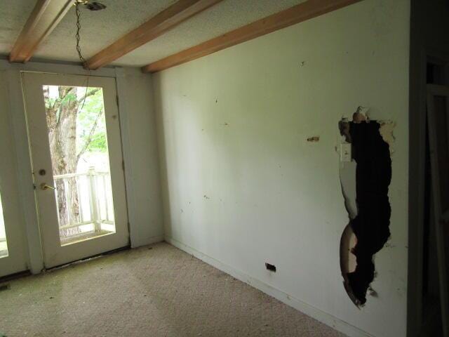 unfurnished room with beamed ceiling