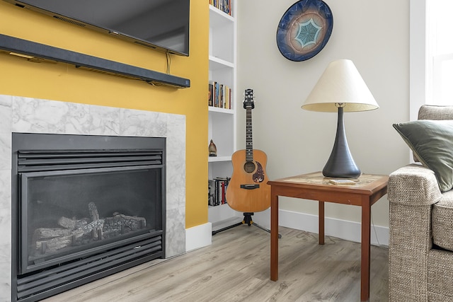 interior details with a high end fireplace, wood-type flooring, and built in features