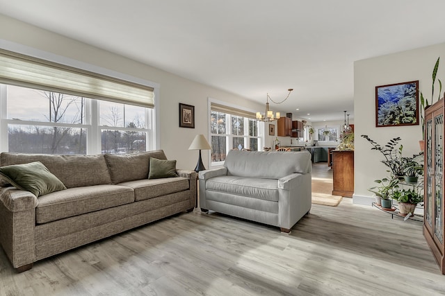 living room featuring light hardwood / wood-style floors and a notable chandelier