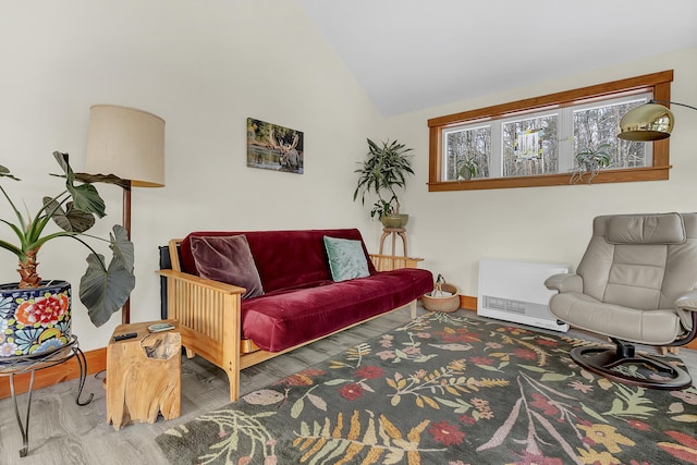 living room featuring hardwood / wood-style floors, vaulted ceiling, and heating unit