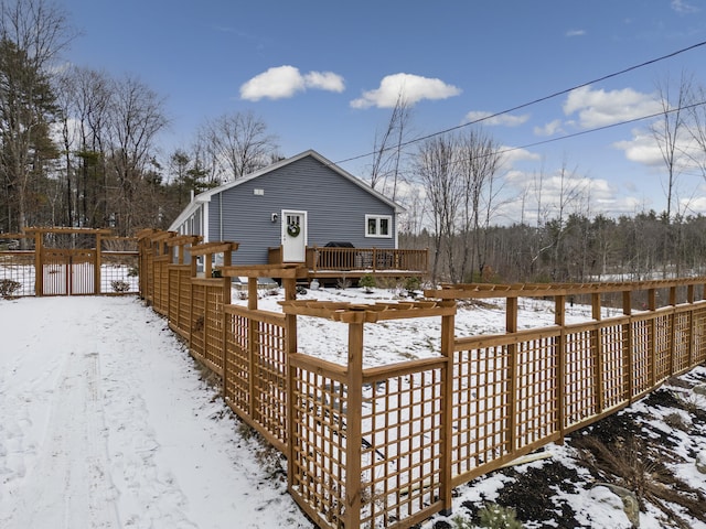 snow covered house featuring a wooden deck