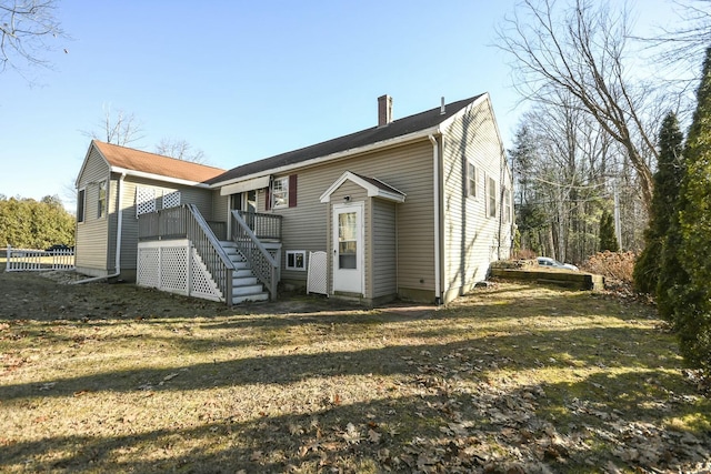 back of property featuring a lawn and a wooden deck