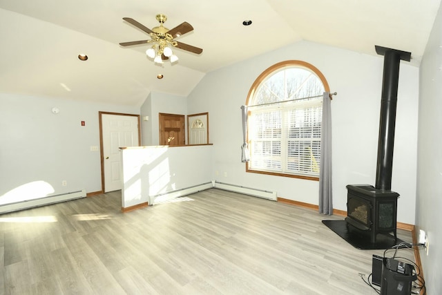 unfurnished living room with ceiling fan, a wood stove, a baseboard radiator, and vaulted ceiling