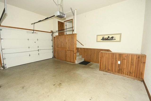 garage with wood walls and a garage door opener