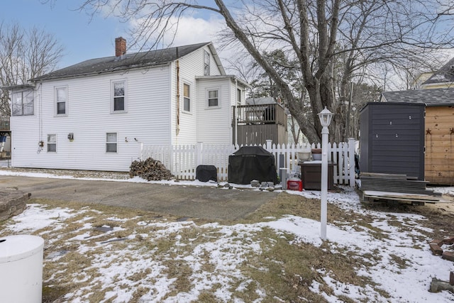 view of snowy exterior with a storage shed