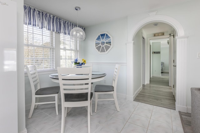 dining area featuring light tile patterned floors and an inviting chandelier