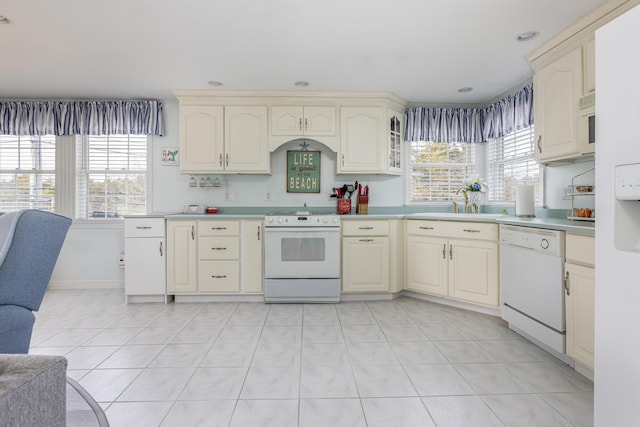 kitchen featuring plenty of natural light, white appliances, and cream cabinetry