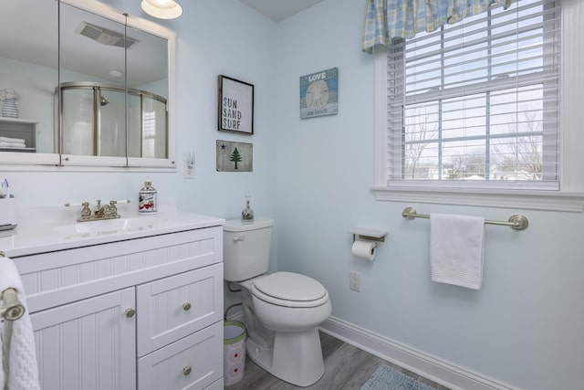 bathroom with toilet, a wealth of natural light, hardwood / wood-style flooring, and vanity