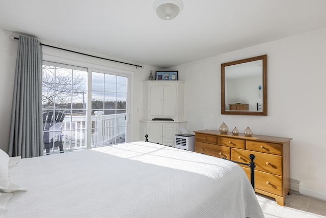 carpeted bedroom with access to outside and a baseboard radiator