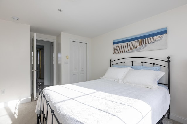 bedroom with light colored carpet and a closet