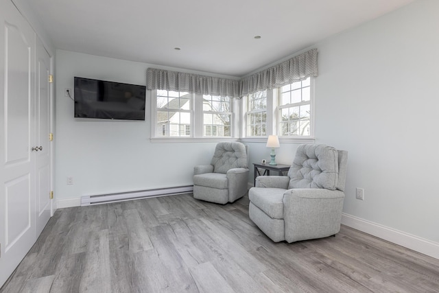 sitting room featuring baseboard heating and light wood-type flooring